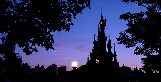 Vier mannen klimmen 's nachts over hek Disneyland Paris
