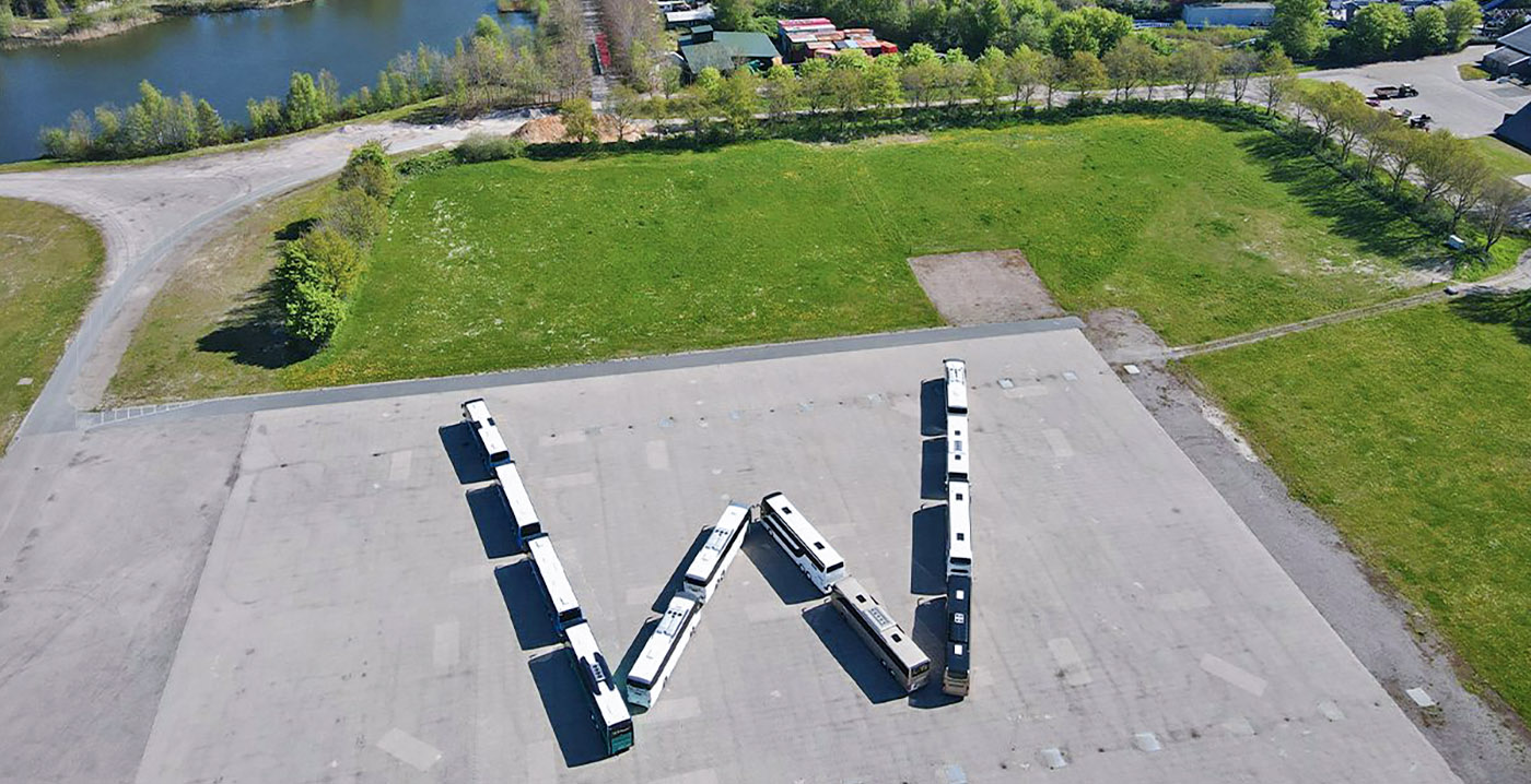 Foto: buschauffeurs vormen Walibi-logo op parkeerplaats